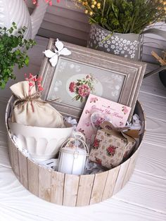 a wooden basket filled with lots of different items next to a potted plant and flowers