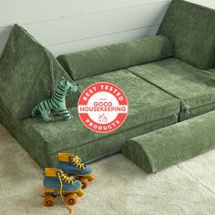 a green couch sitting on top of a white floor next to two blue roller skates