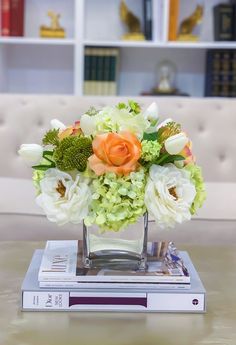 a vase filled with flowers sitting on top of a table next to a bookshelf