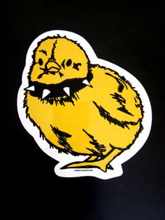 a sticker with a yellow chicken on it's face and eyes, sitting on a black surface