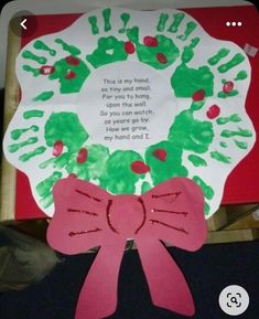 a paper plate with handprints on it and a pink ribbon around the rim