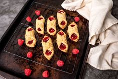 raspberry scones on a baking sheet with fresh berries