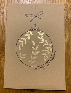 an ornament is hanging on a card that says merry christmas written in black ink