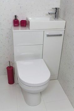 a white toilet sitting in a bathroom next to a sink