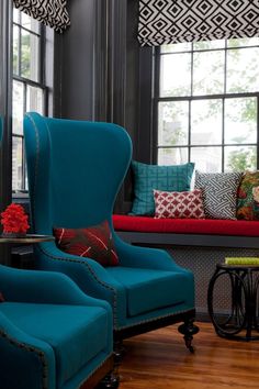 a living room filled with blue chairs and pillows