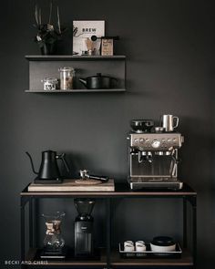 a coffee bar with two shelves above it and some cups on the table next to it