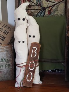 two white pillows and a wooden sign sitting on the floor in front of a chair