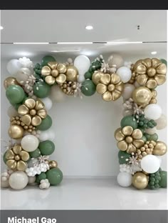 the balloon arch is decorated with gold, white and green balloons