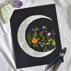 an image of a painting with flowers and leaves in the shape of a half moon