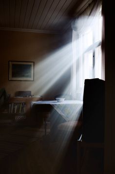 the sun shines through an open window onto a dining room table