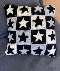 a black and white crocheted pillow sitting on top of a couch