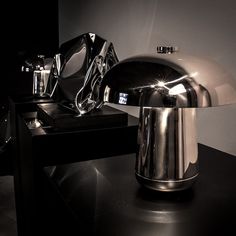 a shiny silver object sitting on top of a table next to a black countertop