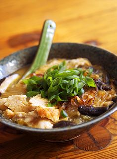 a bowl filled with soup sitting on top of a wooden table