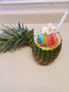 a pineapple with ice cream and sprinkles next to a pineapple