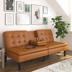 a living room with a couch, coffee table and pictures on the wall above it