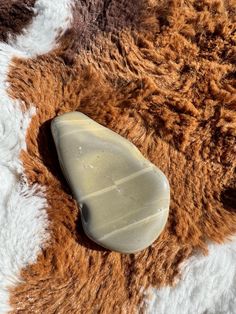 a brown and white animal skin with a stone on it