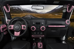 the interior of a car with pink trims and steering wheel controls, along with mountains in the background