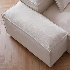 a white couch sitting on top of a hard wood floor