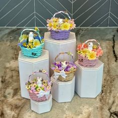 several small baskets with flowers in them sitting on top of a counter next to each other