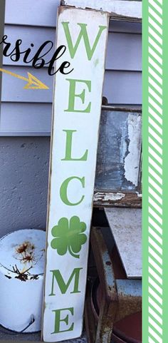 a wooden welcome sign sitting on the side of a building next to a trash can