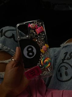 someone is holding up their phone case with the number 8 on it and candies