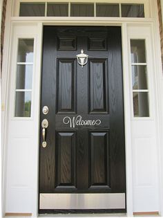 a black front door with no soliciting written on the side and hearts painted on it