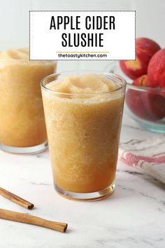 two glasses filled with apple cider slushie on top of a marble counter