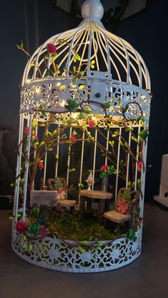 a white birdcage with flowers and lights inside