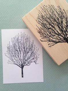 a rubber stamp with a tree on it next to a piece of paper that has been printed onto