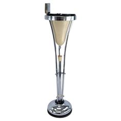 a tall metal stand with a wine glass on it