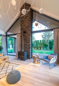 a living room filled with furniture and a fire place next to a large glass window