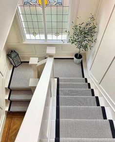 stairs leading up to the second floor in a house with white walls and black trim