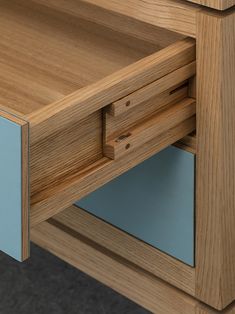 a close up view of a wooden desk with blue glass drawer doors and wood grained surface