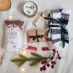 the contents of a christmas gift laid out on a bed next to some candles and other items