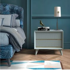 a bedroom with blue walls and a white nightstand next to a bed in the corner