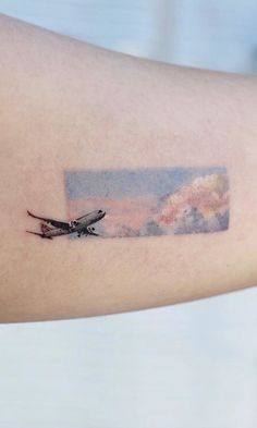 a watercolor painting style dragonfly tattoo on the arm