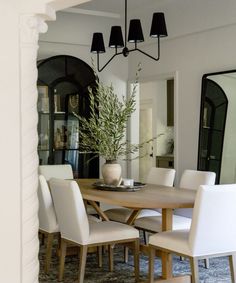 a dining room table with white chairs around it