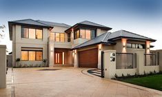 a large house with two garages and an attached walkway leading to the front door