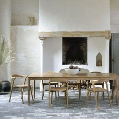 a dining room table and chairs in front of a fire place with an open fireplace