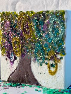 the painting is made with glitter and has a tree on it