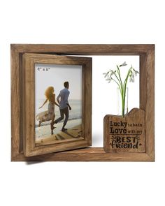 a wooden frame holds a photo and a vase with flowers