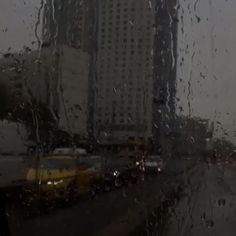 rain is pouring down on the windshield of a car in front of a tall building