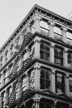 a black and white photo of a building with fire escapes