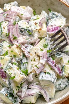 a close up of a salad in a bowl with a fork