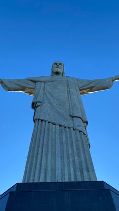 the statue of christ is in front of a blue sky