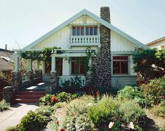 a house with flowers and plants around it