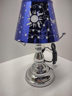 a blue lamp with white stars on it and a cord plugged into the base