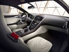 the interior of a modern car with leather trims and red stitching on the steering wheel