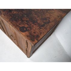 an old wooden box with metal handles on the top and bottom, sitting on a white surface