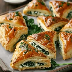 several pastries on a plate with greens and sauces in the background, ready to be eaten